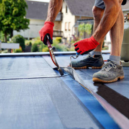 worker applying a commercial roof coating