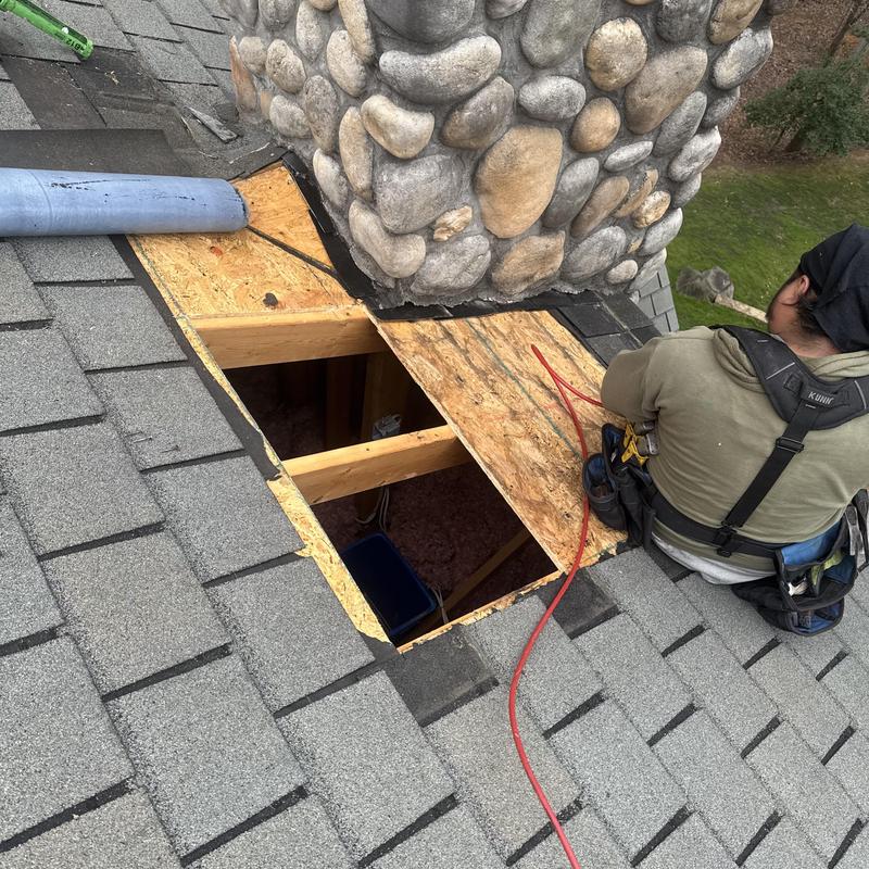 workers repairing a shingle roof